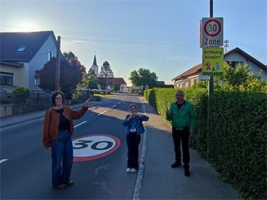  Vizebürgermeister Friedrich Sulyoik (re.), Gemeinderätin Brigitte Schendl (li.) und Anna freuen sich über die umgesetzte Tempo-30-Zone im Ortskern von Mischendorf.