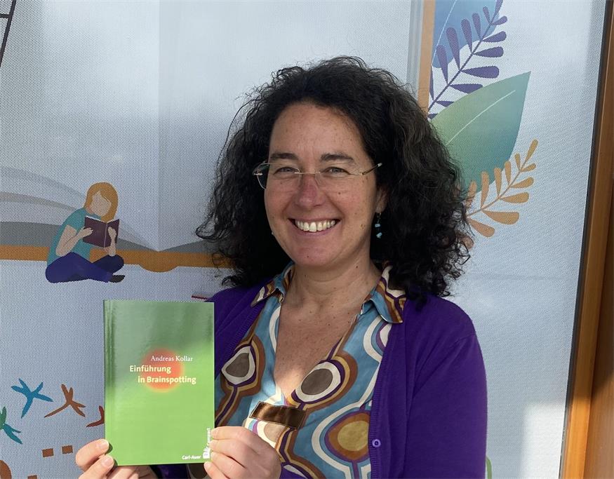 Batrix Bojarra zeigt das Buch von Andreas Kollar.
