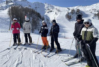 Wintersportwoche mit Sonnenbrille, Schneeflocken und Muskelkater