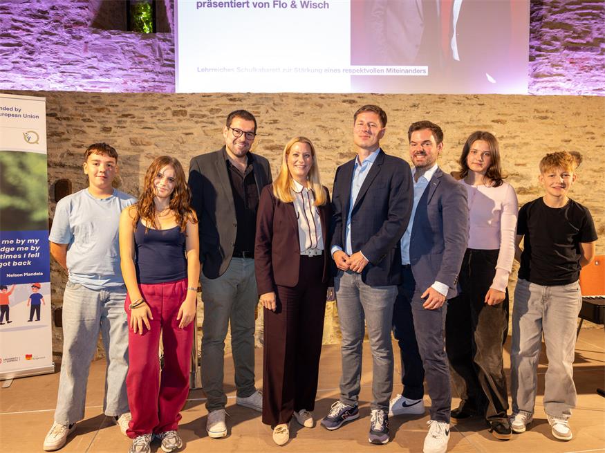 Bildungslandesrätin Daniela Winkler und Tobias Lang mit Schülerinnen und Schülern und dem Kabarett-Duo Flo & Wisch in Stadtschlaining.