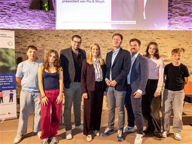 Bildungslandesrätin Daniela Winkler und Tobias Lang mit Schülerinnen und Schülern und dem Kabarett-Duo Flo & Wisch in Stadtschlaining.