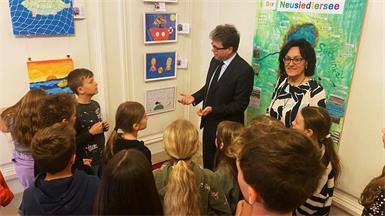 Bildungsminister Martin Polaschek, Direktorin Luise Feiler und die Kids der vierten Klasse der Volksschule Mörbisch mit einigen ihrer Kunstwerke zum Thema Neusiedler See.