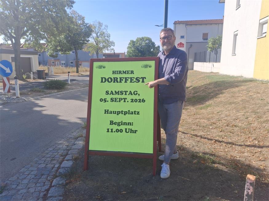 Bürgermeister Christian Wöhl beim Plakat zum Dorffest - einem Fest von den Hirmer Vereinen für die Hirmer Bevölkerung.