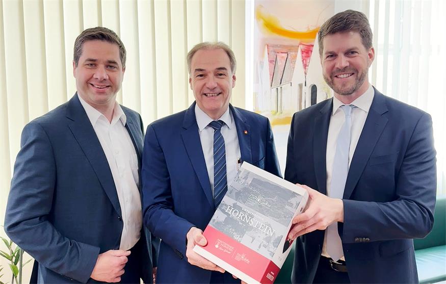Bürgermeister Christoph Wolf (ÖVP) und Vizebürgermeister Rainer Schmitl (SPÖ) brachten Soziallandesrat Leonhard Schneemann (SPÖ) zum Gesprächstermin eine Hornsteiner Ortschronik mit.