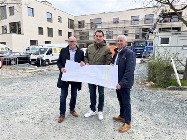 Bürgermeister Georg Rosner, Wirtschaftshof-Leiter Markus Imre und Vizebürgermeister Michael Leitgeb (v.l.) vor dem Haupteingang des neuen Bildungscampus, der ab Herbst die Volksschule, die Zentralmusikschule und den Proberaum der Stadtkapelle beherbergen wird.