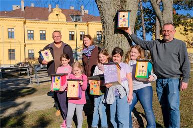Bürgermeister Gerhard Dreiszker und Umweltgemeinderat Bernhard Schütz mit den fleißigen Kindern und den ersten fertigen Nistkästen. 