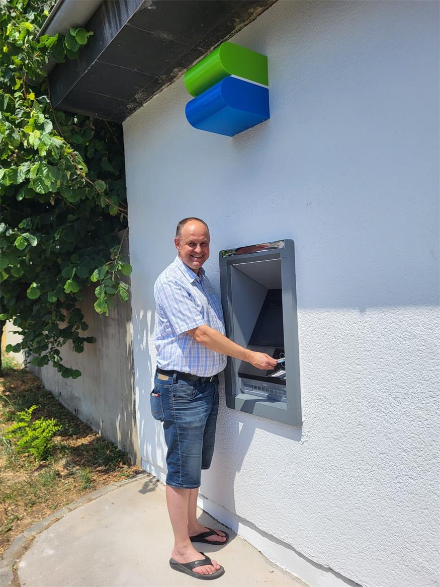 Bürgermeister Karel Lentsch beim ersten Bankomaten seiner Gemeinde.