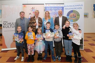Clusterleiter Norbert Kappel, Thomas Brezina, Landesrätin Daniela Winkler und Bürgermeister Hannes Schmid mit den lesebegeisterten Kindern.