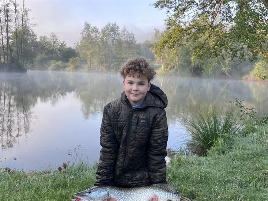 Der 13-jährige Jonas am Fischteich in Unterrabnitz mit einem selbstgefangenen Hecht.