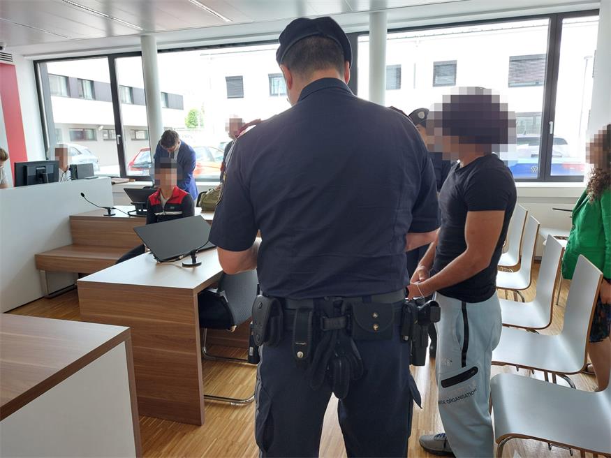 Der 21-Jährige - rechts neben dem Justizwachebeamten - wurde bei zwei Überfällen von einem 16-Jährigen - auf der Anklagebank sitzend - begleitet.