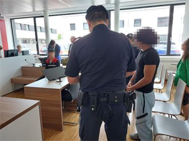 Der 21-Jährige - rechts neben dem Justizwachebeamten - wurde bei zwei Überfällen von einem 16-Jährigen - auf der Anklagebank sitzend - begleitet.