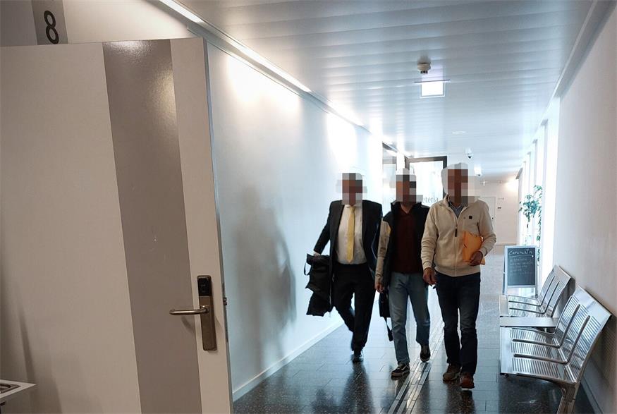 Der Angeklagte (ganz rechts) wurde am Weg in den Gerichtssaal von seinem Anwalt und seinem Sohn begleitet.