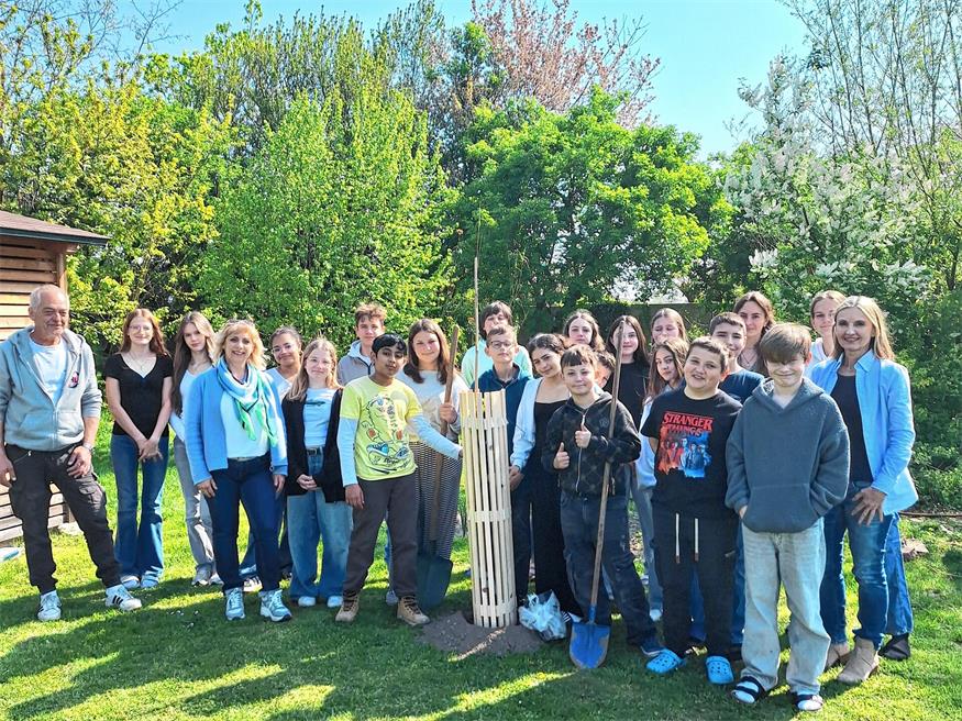 Die fleißigen Schülerinnen und Schüler beim Einsetzen einer Elsbeere, die sie als Ökolog-Preis erhalten haben.