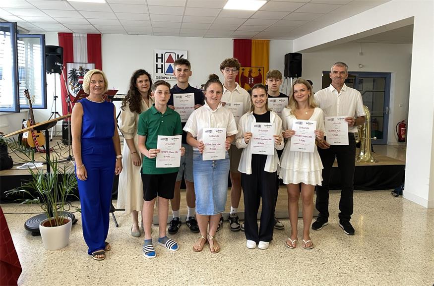 Direktorin Sonja Hasler und Klassenvorständin Stefanie Feck-Fleischhacker mit den Erstplatzierten Mario Leitner (Walken), Leon Maschler, Leoni Katava, Tobias Kulman, Anna Lena Rohrer, Daniel Mihalin, Sophie Hasler und Prof. Kurt Supper (alle Laufen). 