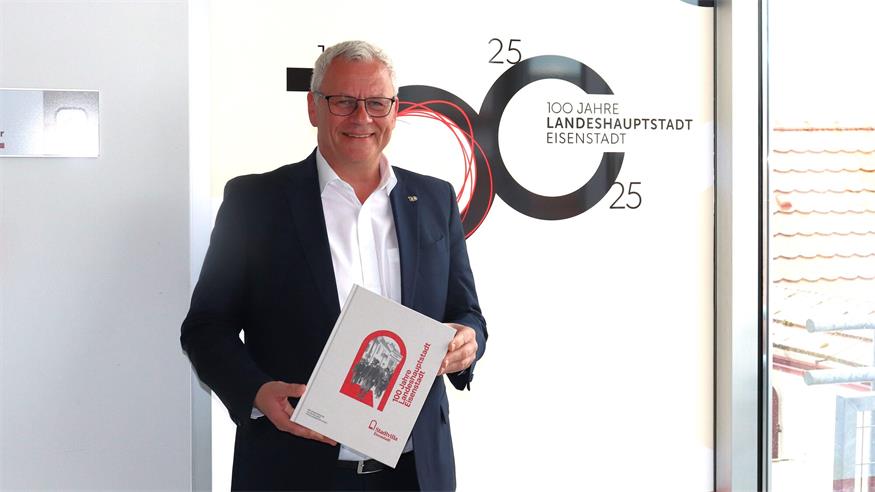 Eisenstadts Bürgermeister Thomas Steiner präsentiert den Begleitband zur 100 Jahre Landeshauptstadt-Feier.
