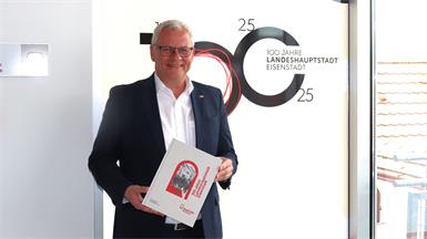 Eisenstadts Bürgermeister Thomas Steiner präsentiert den Begleitband zur 100 Jahre Landeshauptstadt-Feier.