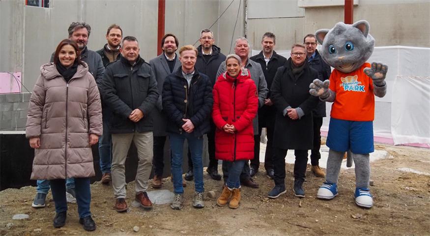 Foto mit den Vertretern des Bauherren, der Baufirmen und der Gemeinden vor dem Rohbau des neuen Restaurants