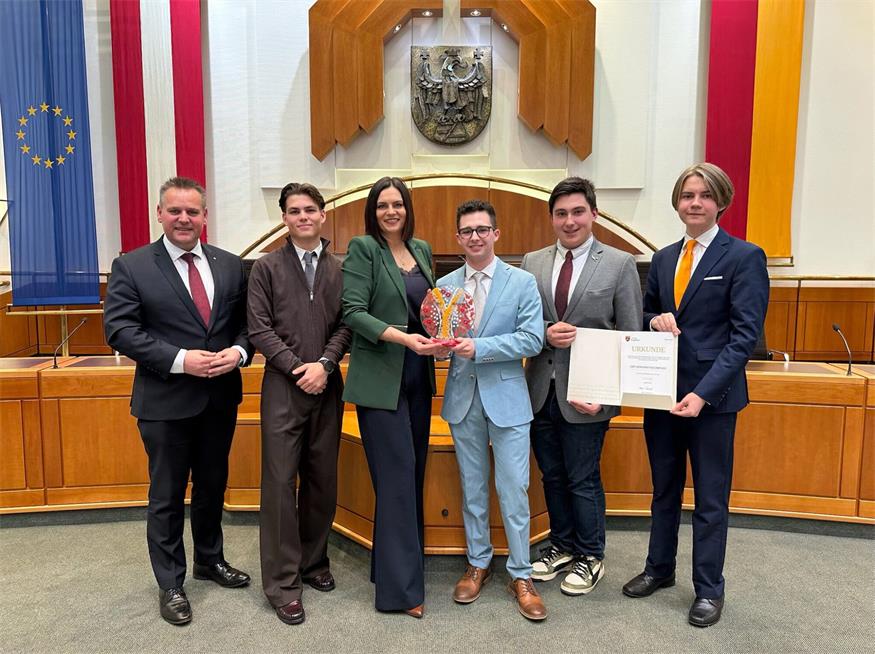 HTL-Direktor Thomas Schober und Landtagspräsidentin Astrid Eisenkopf gratulieren Fabian Jelleschitz, Pascal Kratochwil, Jannik Stettner und Jens Brueren zum 1. Platz beim Demokratiewettbewerb.