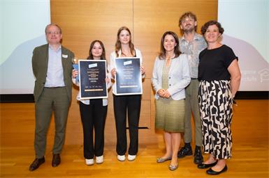 KARDEA! Finanzbildungspreis für HAK Neusiedl. Hannah Schmid (2.v.l.) und Michaela Pinter (3.v.l.) nahmen die Auszeichung entgegen. FLiP-Direktor Philip List, Vorstandsmitglied der ERSTE Stiftung Gudrun Egger, Moderator Christof Moro und Lena Gugenberger (Three Coins) gartulierten den Preisträgerinnen.