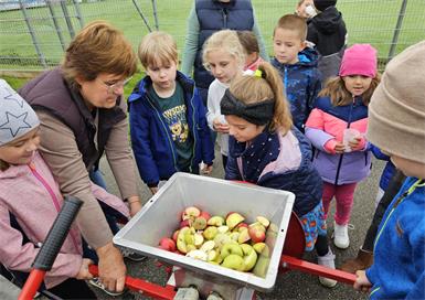Kinder der 1. und 2. Schulstufe mit Klassenlehrerin Barbara Loibl bei der Apfelpresse.
