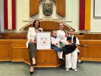 Landtagspräsidentin  Astrid Eisenkopf mit einem Bild der Künstlerin Lisa-Marie Horvath, Hannah von der Kindervolkstanzgruppe Großhöflein, Odette von der ungarischen Tanzgruppe des ZBRG Oberwart und Lovre von der kroatischen Folkloregruppe Poljanci aus Wulkaprodersdorf.