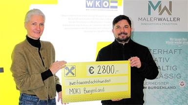 Maler Stefan Waller übergab der Geschäftsführenden Landesvorsitzenden der Mobilen Kinderkrankenpflege (MOKI) Burgenland Doris Zoder-Spalek den Scheck über 2.800 Euro.