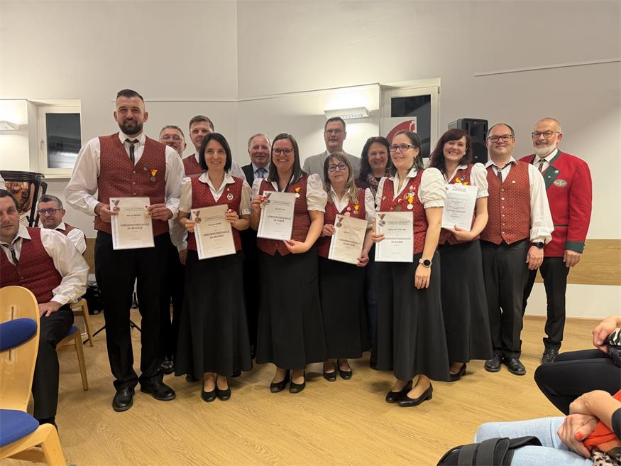 Marco Weber, Kapellenmeister Andreas Heschl, Michael Pauer, Theresa Kainz, Josef Thurner, Pia Stifter, Bezirksobmann Richard Wolfram, Klara Schermann, Corina Gmeiner, Katrin Stifter, Doris Janisch, Vereinsobmann Martin Hetlinger, Bezirksobmann Richard Wolfram und Ehrenobmann Erwin Stifter bei der Ehrung.