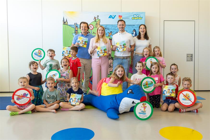 Michael Zacek (Blue Circus), Landesrätin Daniela Winkler, Philipp Pelzer (Bürgermeister Andau), Lisa Sachslehner (Leitung Kindergarten Andau) mit teilnehmenden Kindern. 