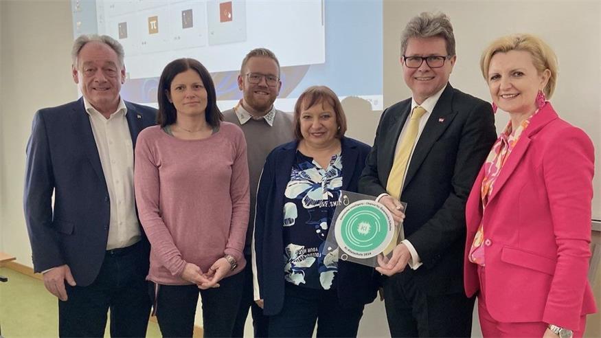 Minister Martin Polaschek mit Neudörfls Bürgermeister Dieter Posch, Schuldirektorin Karin Sinawehl, Sandra Steiner (Bildungsdirektion Burgenland) und Vertretern der Schule bei der Zertifikatsübergabe.