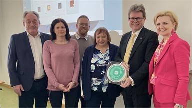 Minister Martin Polaschek mit Neudörfls Bürgermeister Dieter Posch, Schuldirektorin Karin Sinawehl, Sandra Steiner (Bildungsdirektion Burgenland) und Vertretern der Schule bei der Zertifikatsübergabe.