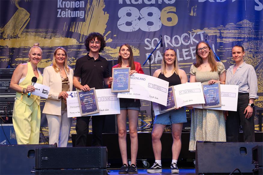 Moderatorin Rozalija Gregurek, Landesrätin Daniela Winkler, Zweitplatzierter Benjamin Gedeon, die strahlende SongChallenge-Siegerin Sofia Reyna, die Preisträgerinnen Lizalu und Lisa Seidl sowie Bianca Benedikt, Leiterin des Landesjugendreferats, bei der Siegerehrung. 