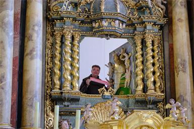 Pater Thomas Lackner bei der Gnadenmutter Maria auf der Heide beim Hochaltar, zu deren Füßen er die Schlüssel der Liebesschlösser platziert. 