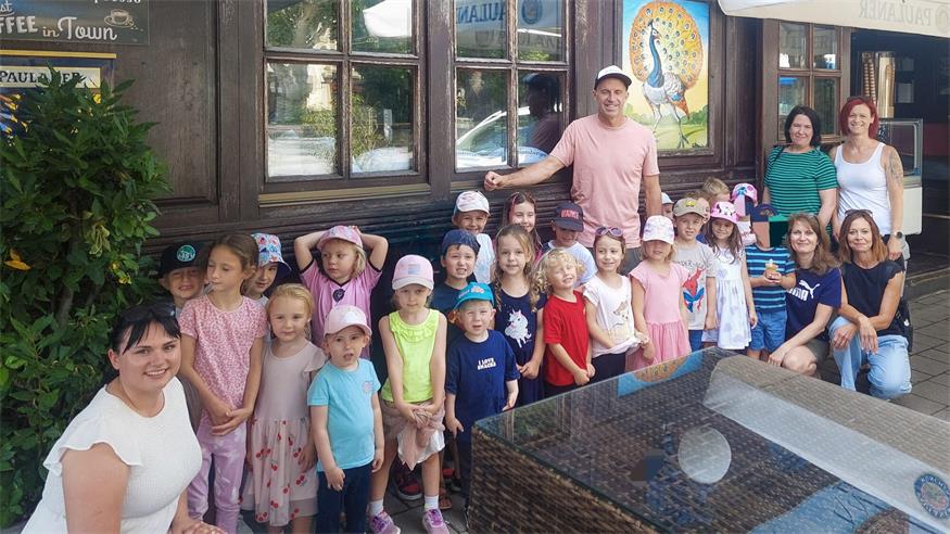 Peacock-Chef Holger Stefanitsch mit den Kinderkartenpädagoginnen und den Kindern.