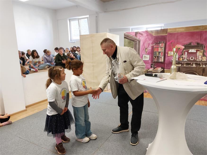 Reinhard Wimmer, früher Wirt im jetzigen Schulgebäude, bedankte sich bei den Erstklasslerinnen für ihr Präsent - eine Tasse mit dem Schullogo.
