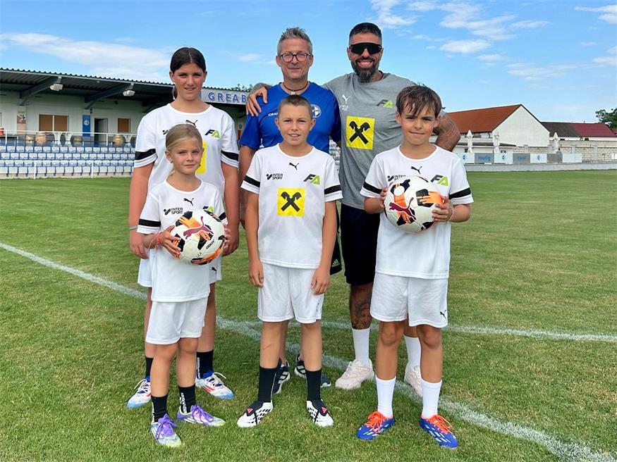 Sophia (Austria Wien), Oscar (FC Sion/Schweiz), Matthias (U10 SV St. Margarethen) (vorne, v.l.) mit Lea (U12 SV St. Margarethen), Nachwuchleiter Markus Ginda und Trainer und Campleiter Alex-Fabiano Frank im Greabochstadion.