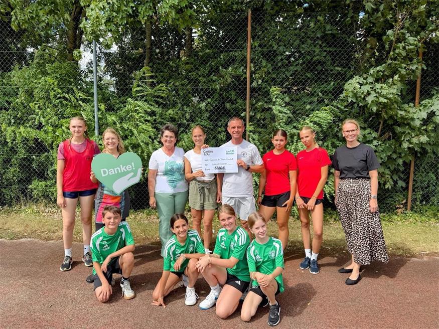 Sport-Lehrkräfte, Direktorin und Schülerinnen und Schüler sind stolz auf den beim LaufWunder erzielten Betrag.
