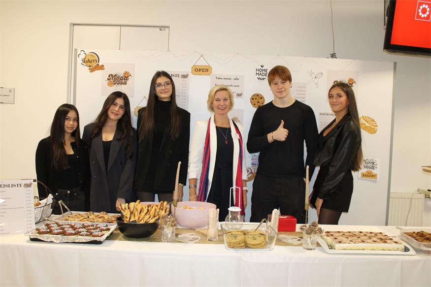 Stefanie Kainzbauer, Helena Pekovits, Yllka Basna, Til Traudtner und Hannah Prybil von der Übungsfirma Bakery – im Bild mit Direktorin Sonja Hasler – hatten allerhand Leckereien für die Gäste vorbereitet. 