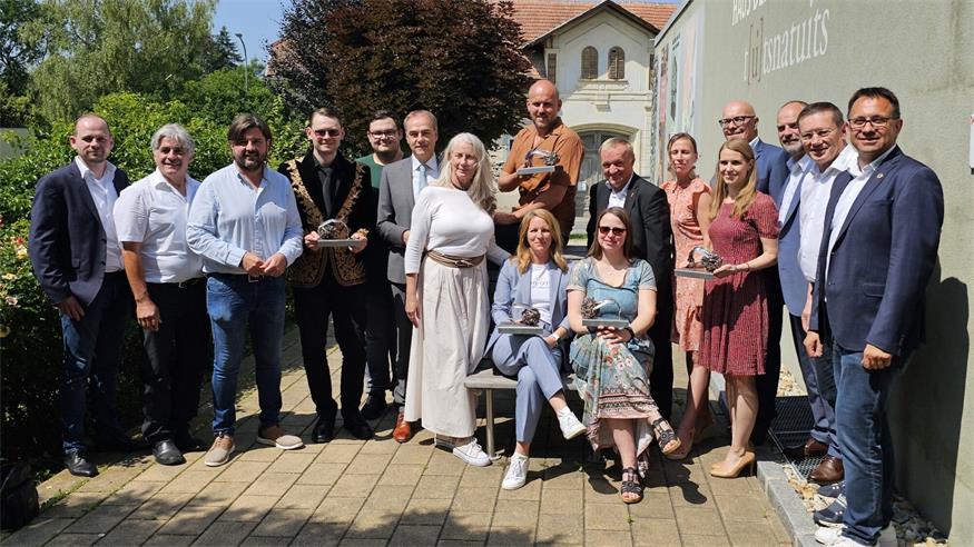 Thomas Sailer (stehend, 4.v.l.) und Christine Neunteufel (sitzend, 2.v.r.), Klassenvorständin der 2B-Klasse , bei der Preisverleihung mit weiteren Preisträgern und Ehrengästen.