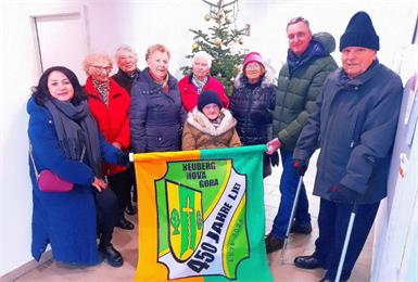 Vizebürgermeisterin Birgit Karner, Maria Kovacs, Eugenia Kulovits, Paula Knor, Theresia Rudak, Anna Buchetics (sitzend im Rollstuhl), Esther-Julianne Lohberger, Bürgermeister Thomas Novoszel und Alexander Karner mit der Jubiläumsfahne.