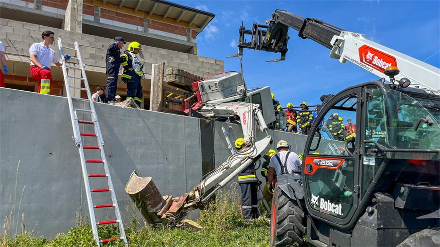 Bagger bei Arbeiten an Stützmauer umgekippt