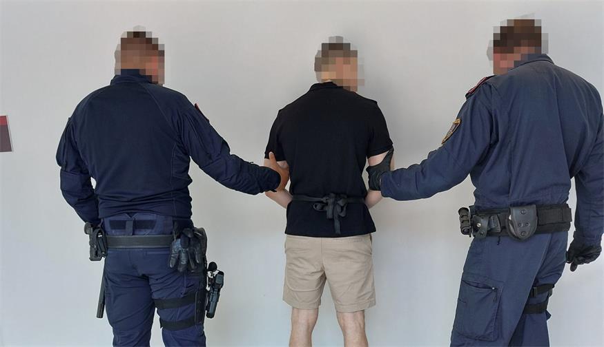 Wegen seines renitenten Verhaltens wurde der Angeklagte unter strenger Bewachung in den Verhandlungssaal gebracht.