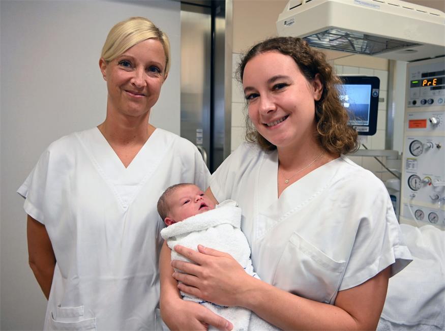 v.l.n.r DGKP Nicole Dörfler und Hebamme Tanja Gruber, BSc mit dem 500. Baby im Arm .